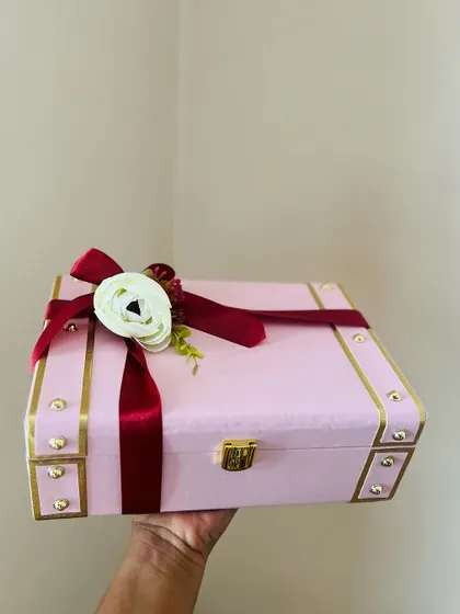 The packaging is the first impression. This beautiful pink and gold trunk box, held in hand, shows the quality and elegance of my premium options before you even see the curated gifts inside.