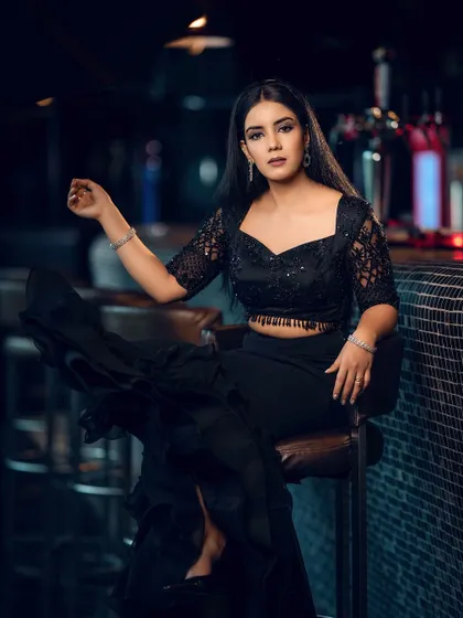 A confident pose with a direct gaze. The lighting highlights the texture of the lace top and the model's features, creating a powerful editorial image.
