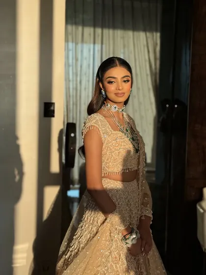 The play of light and shadow in this photo highlights the glowing skin and shimmery details of the makeup. This is a key technique for evening looks.