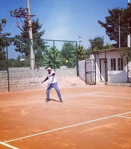 A male player returns a shot during a singles match at the Tennis360 Open Tournament.