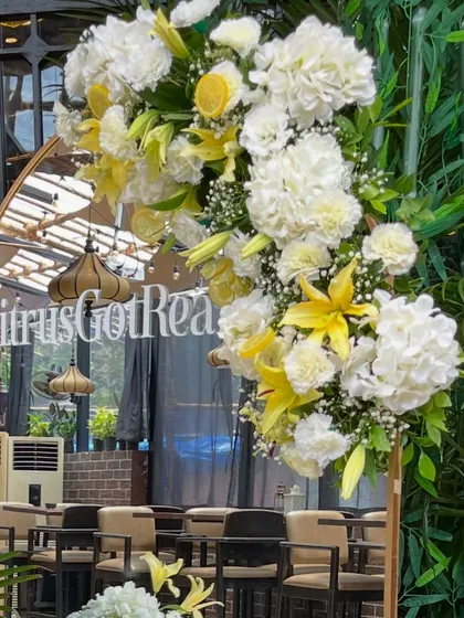 For a "Citrus Got Real" themed baby shower, I designed this elegant entrance piece. A gold framed mirror adorned with lush white hydrangeas, yellow lilies, and real lemon slices created a fresh and vibrant welcome for a zesty celebration.