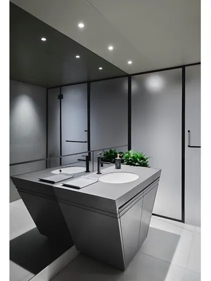 The gym's bathroom continues the modern aesthetic with a custom-designed vanity, sleek fixtures, and a monochrome color scheme.