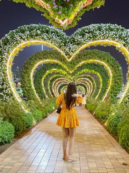 Standing in the famous heart tunnel at the Dubai Miracle Garden. This bright yellow dress was the perfect choice for such a colorful and romantic location.