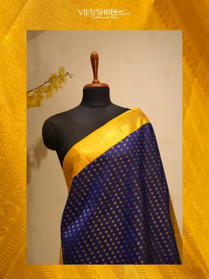 A royal blue Kanjivaram with gold polka dots and a bright yellow border, a vibrant and joyful choice.