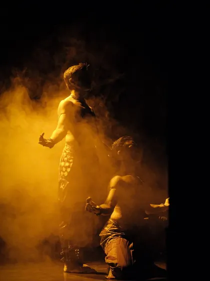 Adithya PV and I in a moment of synchronized movement during 'ATAH'. The use of smoke and warm lighting enhances the dynamic energy of the scene.