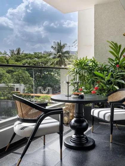 The balcony seating area, perfect for morning coffee or evening drinks. Our custom chairs blend traditional materials like cane with modern design sensibilities.