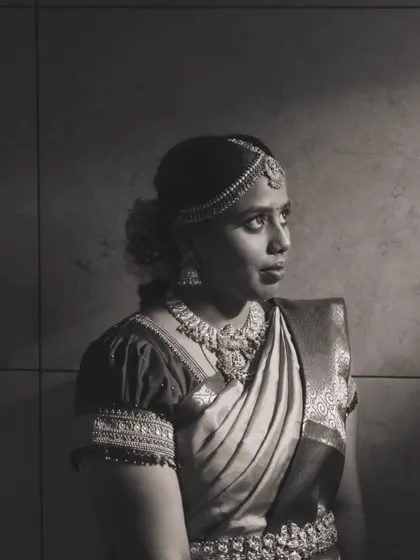A black and white photo that captures the timeless elegance of Priya's muhurtham look. The focus is on her expression and the beautiful jewelry.