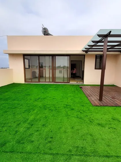 The foundation of a great terrace garden. This image shows a freshly installed artificial lawn and wooden deck, creating a clean and versatile base for future plants and furniture.
