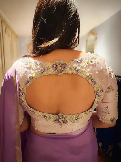 The back of the blouse I designed for Divya Spandana is a work of art in itself. The keyhole cutout is beautifully framed with intricate floral embroidery, showing how I focus on making every angle of an outfit special.