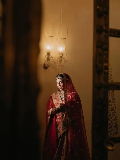 A candid shot of Tanya, full of grace and happiness. The image captures her in a moment of quiet joy, framed by the elegant architecture of the venue.