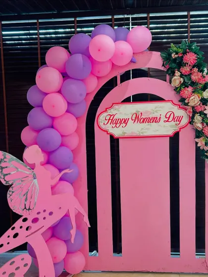 A simple yet beautiful decoration for Women's Day. The pink backdrop is adorned with a fairy cutout and a pink and purple balloon cluster.