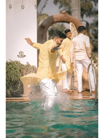 The groom's friends adding a splash of fun to the Haldi celebrations by jumping into the pool. We are always ready to capture spontaneous moments of joy.