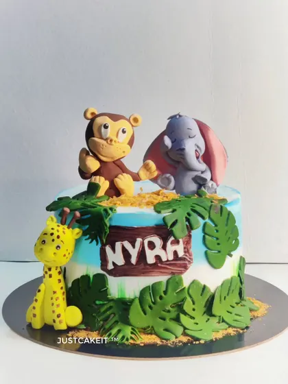 A fun jungle theme cake with a mixed fruit flavor inside. I crafted these cute edible animal figures, including a monkey, elephant, and giraffe, to bring the wild theme to life.