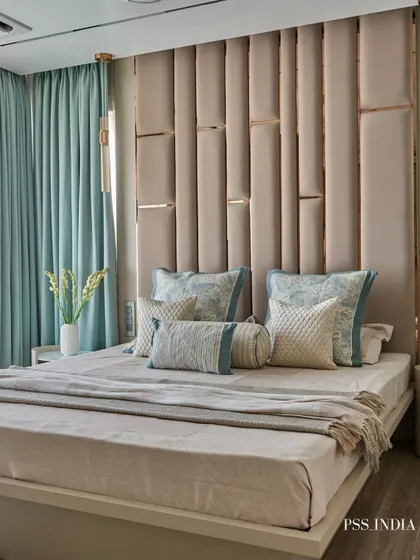 A tall, upholstered headboard in a soft beige creates a sense of grandeur in this bedroom. I used pops of tranquil blue in the curtains and cushions to add a refreshing contrast to the neutral palette.