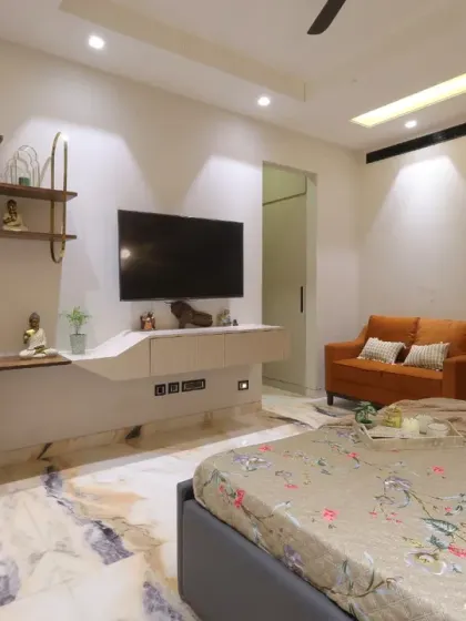 The room includes a sleek floating TV unit and a compact study area, blending functionality with style for a complete guest experience.
