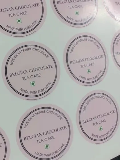 Elegant pink stickers designed for 'Belgian Chocolate Tea Cake', specifying that it's made with 100% couverture chocolate.