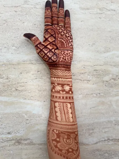 A single-arm view of a bridal design, featuring fish motifs, paisleys, and dense check patterns.