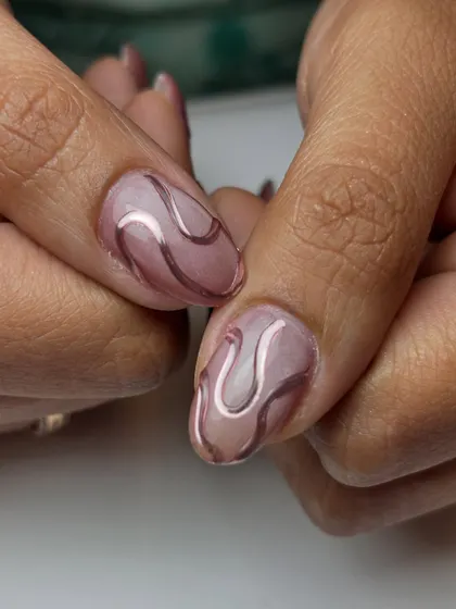 A close-up of the chrome heart and swirl design on a shimmery cat-eye base. The 3D effect of the chrome is really eye-catching.