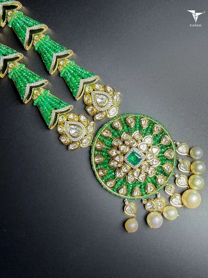 A perfect blend of modern and traditional design, this Polki and emerald necklace is sure to complete any look you put together, whether for a wedding or a grand celebration.