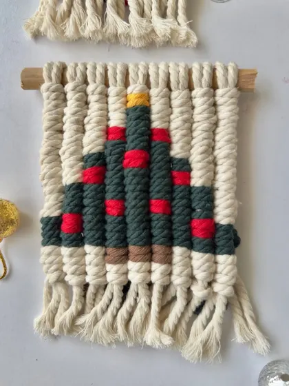 This macrame Christmas tree wall hanging is decorated with little red "ornaments."