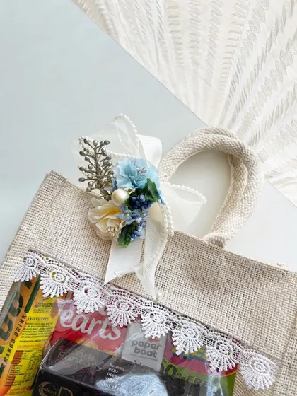 A detailed shot of the lace and floral accent on our destination wedding welcome bag. It's these small, thoughtful details that elevate a simple gift into something special.