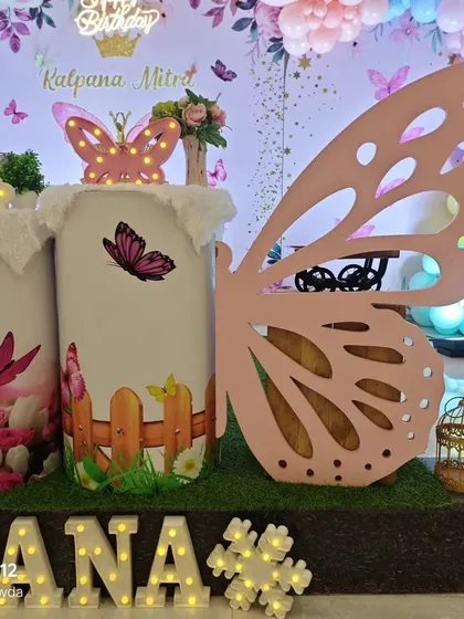 A detailed shot showing the large butterfly wing prop and a plinth decorated with a cute fence and butterfly design.