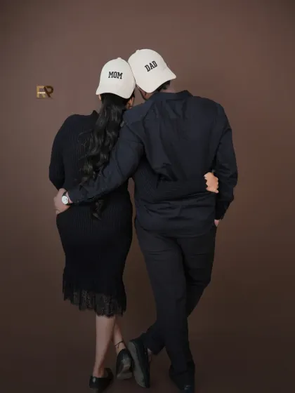 Mom and Dad. This fun shot with matching caps is a creative way to celebrate your new roles. It's a playful and modern take on the couple's maternity portrait.