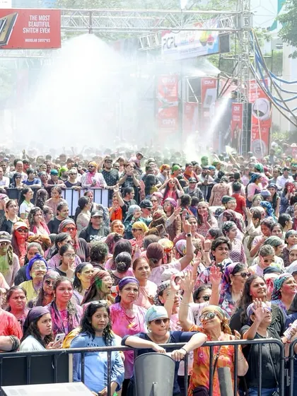 The huge crowd at the Holi festival enjoys the celebration as water and colors fill the air. We manage all aspects of crowd safety and experience, including amenities like rain dance setups.