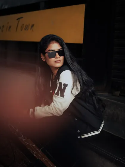 A moody, low-light portrait of a model on the street. The shadows and her cool expression create a mysterious and edgy vibe.