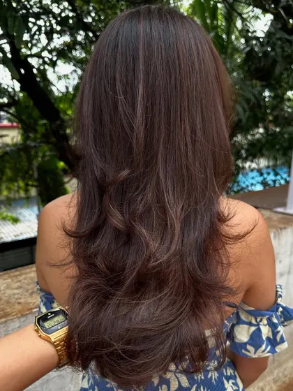 The back view of a subtle color refresh and layered cut, styled with a classic blowout.