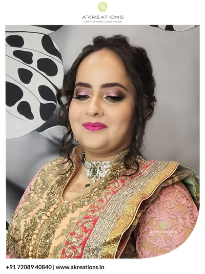 This glamorous festive look features a striking pink smokey eye and a bold lip, paired with an intricate updo to complement the client's ornate traditional attire.