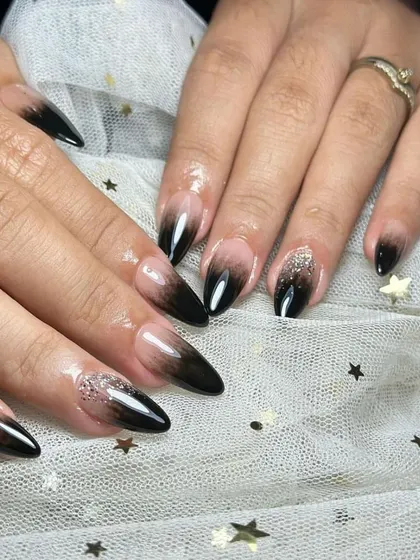 A smoky and dramatic black ombré on long stiletto nails, with a touch of silver glitter for a bit of sparkle.