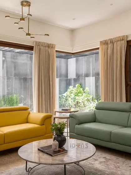We love using color to bring personality into a space. In the Prakash Reddy residence, we paired vibrant yellow and serene green sofas against a backdrop of large windows, creating a cheerful and bright living area that is connected to the garden outside.