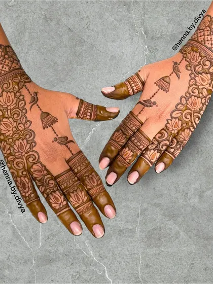 This design is a celebration of Indian artistry, featuring a mix of lotus flowers, birds, and hanging jhumkas. The pattern is intricate yet feels light and elegant.