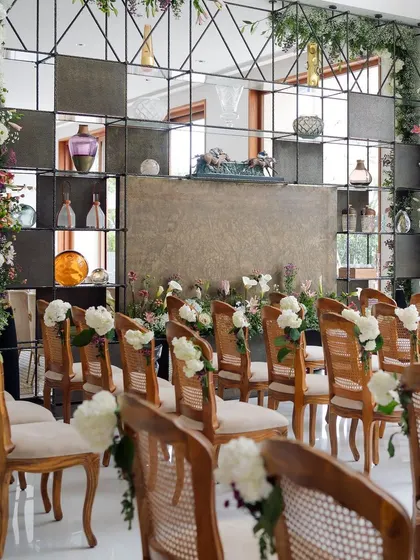 The indoor seating arrangement for the engagement, with a modern shelving backdrop filled with art pieces, perfectly balanced by floral columns.