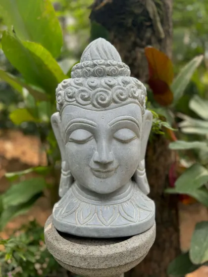 A stone Buddha bust with a serene expression, perfect for adding a touch of tranquility and mindfulness to your garden or home.