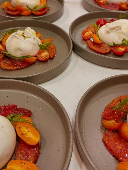 Fresh Tomato Burrata Carpaccio, plated and ready to be served. This dish from our Italian menu is a simple yet divine combination of creamy burrata and sweet tomatoes.