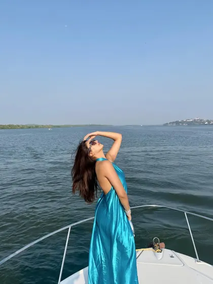 "Everything's worth it in the end." A dramatic shot on the bow of a yacht in Goa, wearing a flowing blue halter dress.