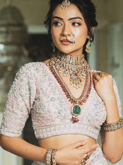 Twirl into a fairytale with this baby pink bridal lehenga. I designed it with intricate horse embroidery on the raw silk skirt and paired it with a heavily handworked blouse and a delicate net dupatta for a truly heavenly look.