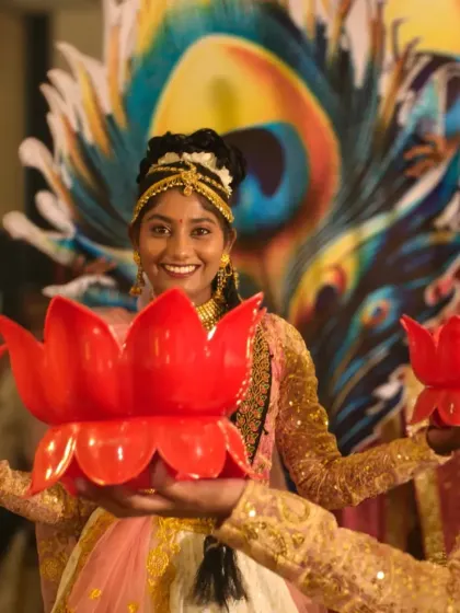 A close-up of our performer during a welcome dance. The combination of the peacock feather backdrop and lotus diyas showcases our ability to blend different traditional motifs.