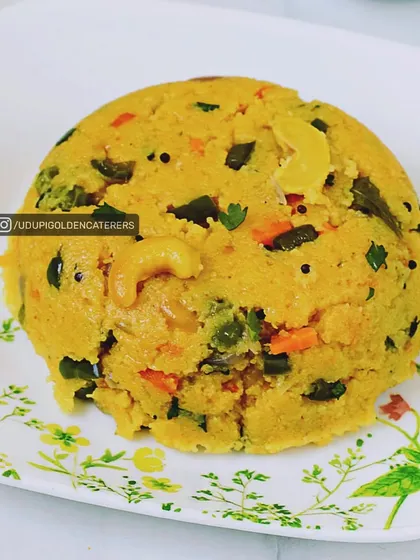 A serving of our delicious vegetable Upma, cooked with semolina, mixed vegetables, and cashews. This is a wholesome and comforting breakfast option.