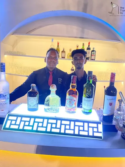 Two of our bartenders behind an illuminated bar, ready for a night of celebration. Our team is trained to work with any setup and deliver a brilliant performance.