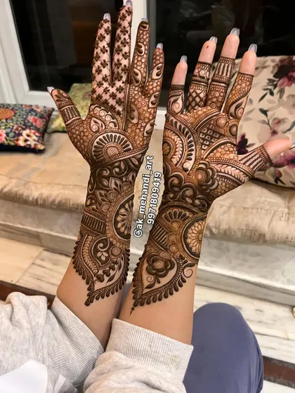 This full-coverage bridal design extends from the fingertips to the mid-forearm. The use of different filler patterns and bold outlines creates a stunning 3D effect.
