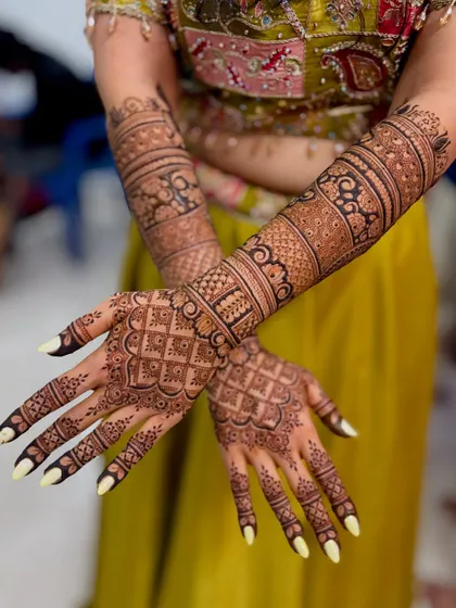 A view of the back of the hands, showing the continuous and intricate pattern work.