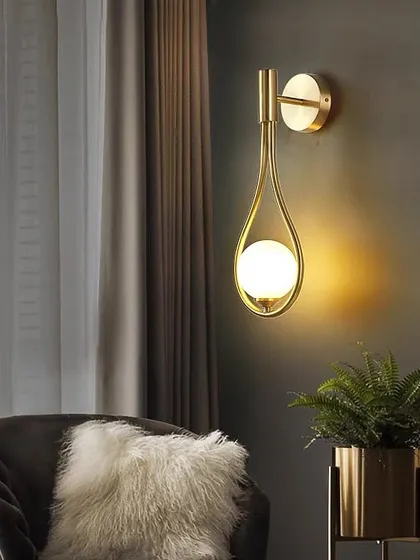 I designed this wall light to feel like a drop of light. The single opal sphere is cradled in a teardrop-shaped golden frame, creating a soft, celestial glow. It's a simple yet elegant addition to a cozy corner or hallway.