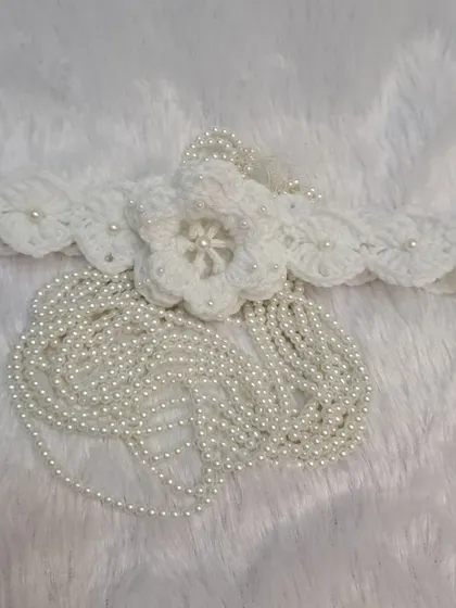 This beautiful headband is designed to match my pearl-accented booties, featuring a large crochet flower with a cascade of delicate pearl strings.