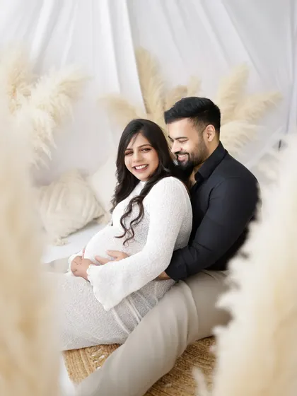 A joyful couple's portrait in a bright, airy setting. Their happy smiles and the "Ready to POP!" sign add a touch of fun to the photo.