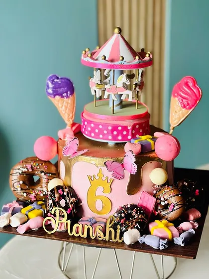 Step right up! Our Carnival Cake is a feast for the eyes, featuring a spinning carousel, ice cream cones, donuts, and a cascade of candies for a truly festive celebration.