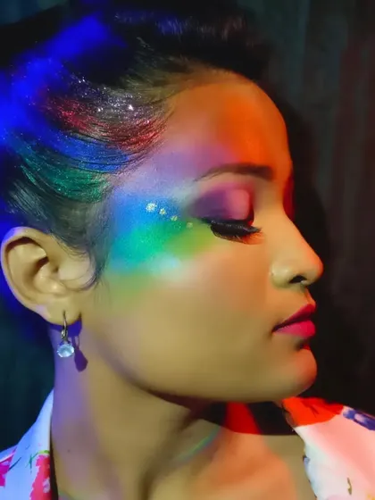 A close-up of the Holi makeup under dramatic lighting, highlighting the glitter and the intensity of the pigments.