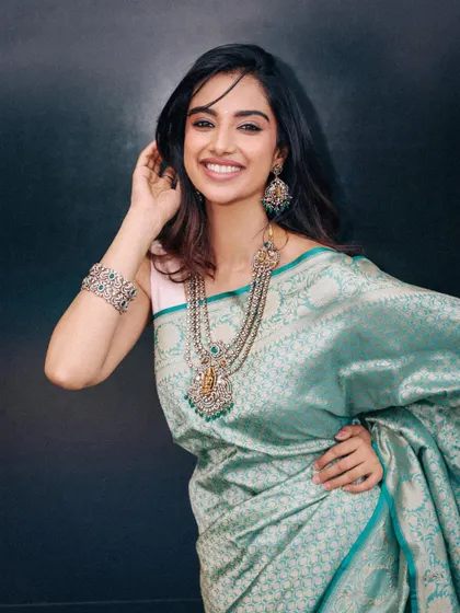 A full look from the teal silk saree series, showing the beautiful drape of the fabric. The addition of a silver bracelet completes the traditional yet understated look.